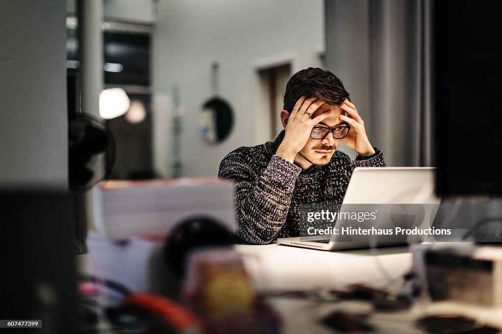 Young businessman holding his head and pondering