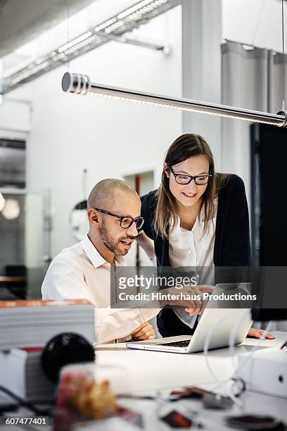 colleagues working late in modern office - computer stock-fotos und bilder