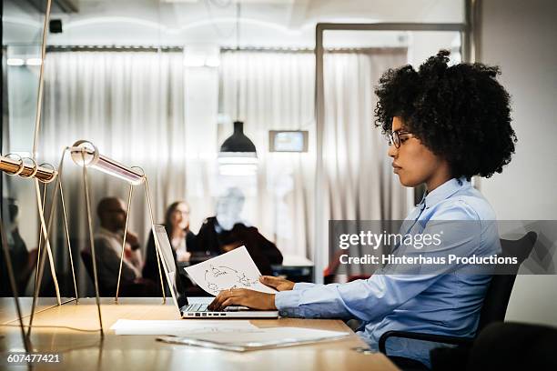 young black businesswoman working in office - profile laptop sitting stock-fotos und bilder