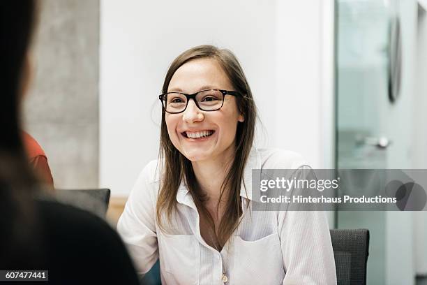 young woman smiling in a business meeting. - candidat fotografías e imágenes de stock