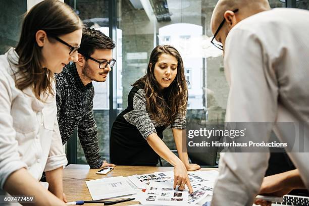 young businesswoman pointing at project papers - leanincollection stockfoto's en -beelden