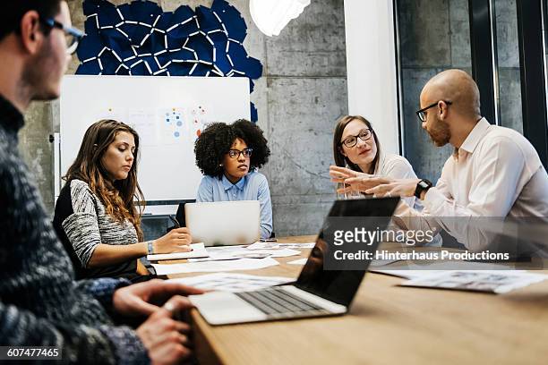 three women and two men in a business meeting. - personas reunidas fotografías e imágenes de stock