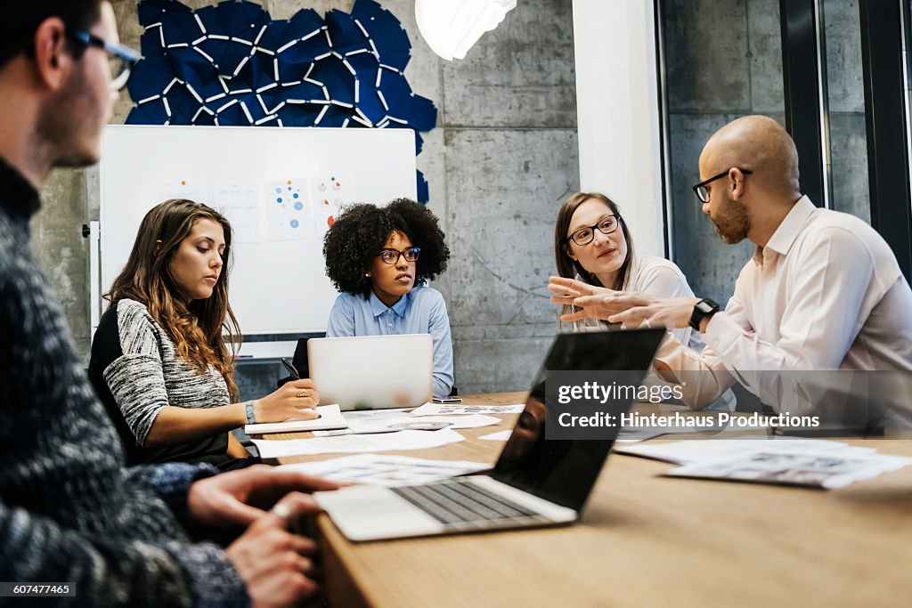 Three women and two men in a business meeting.