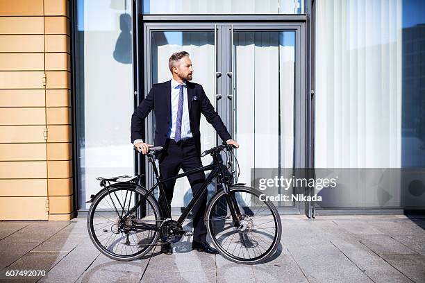 homme d’affaires confiant avec vélo - mitte photos et images de collection