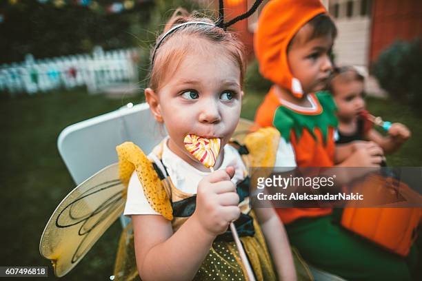 essen einige halloween-süßigkeiten - lollipop man stock-fotos und bilder