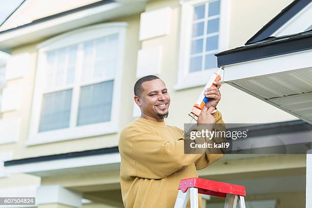 young handyman doing house repairs - caulk stock pictures, royalty-free photos & images