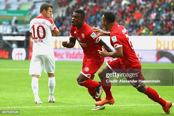 Jhon Andrés Córdoba Copete of Mainz celebrates scoring the opening goal with his team mate Karim Onisiwo whilst Daniel Baier of Ausgburg looks on...