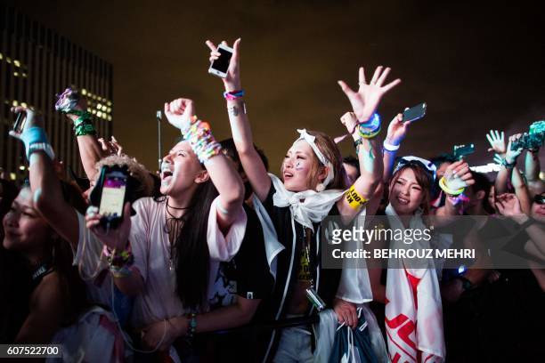 Japanese attend an electronic music concert during the Japan Ultra Music Festival at Odaiba Ultra Park in Tokyo on September 18, 2016.