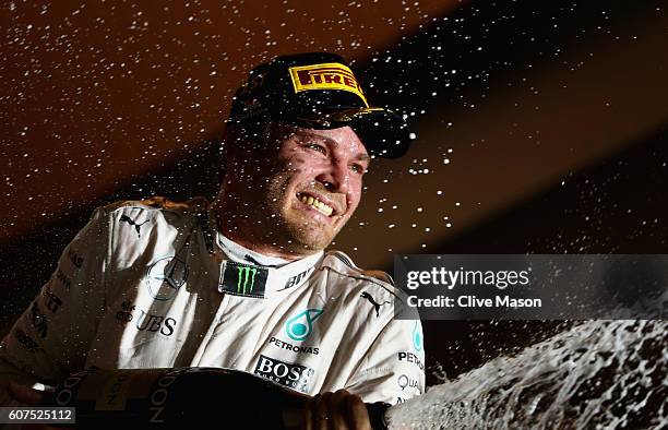 Nico Rosberg of Germany and Mercedes GP celebrates on the podium during the Formula One Grand Prix of Singapore at Marina Bay Street Circuit on...