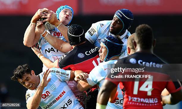 Racing 92's French flanker Wenceslas Lauret grabs the ball next to Toulon's Welsh fullback Leigh Halfpenny and Racing 92's New Zealander flyhalf Dan...