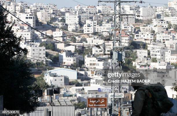 An Israeli soldier stands guard blocking an entrance to the Jewish settlers zone of Hebron's Tel Rumeida neighbourhood, near al-Shuhada street in the...