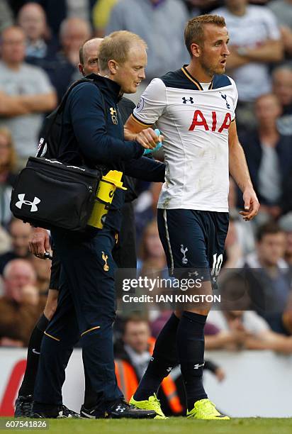 Tottenham Hotspur's English striker Harry Kane is helped up after picking up an injury during the English Premier League football match between...