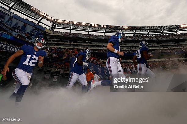 Ryan Nassib, quarterback Eli Manning, Shane Vereen of the New York Giants and teammates take the field before playing against the New Orleans Saints...