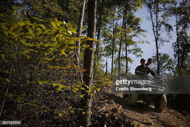 Members of the Kentucky State Police Cannabis Suppression Branch drive an all terrain vehicle down a logging road after confiscating illegal...