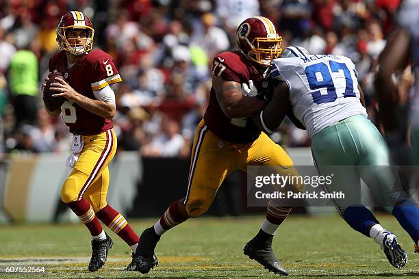 Quarterback Kirk Cousins of the Washington Redskins passes the ball while teammate guard Shawn Lauvao blocks against defensive tackle Terrell McClain...