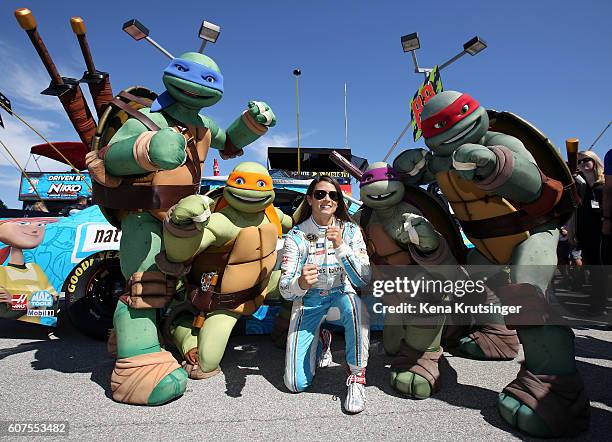 Danica Patrick, driver of the Nature's Bakery/TMNT April O'Neil Chevrolet, poses with the Teenage Mutant Ninja Turtles during the NASCAR Sprint Cup...