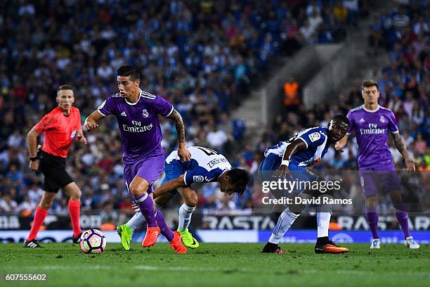 James Rodriguez of Real Madrid CF competes for the ball with Hernan Perez and Pape diopof RCD Espanyol on his way to score the opening goal during...