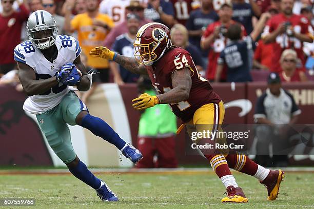 Wide receiver Dez Bryant of the Dallas Cowboys carries the ball against inside linebacker Mason Foster of the Washington Redskins in the fourth...