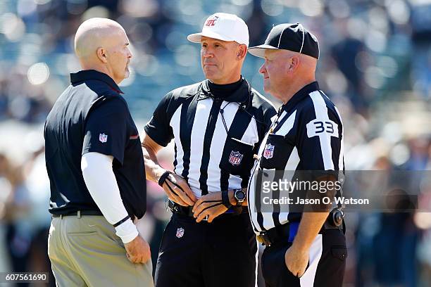 Head coach Dan Quinn of the Atlanta Falcons speaks with referee Clete Blakeman and field judge Steve Zimmer prior to their NFL game against the...