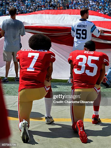 San Francisco 49ers quarterback Colin Kaepernick, left and safety Eric Reid, right, kneel during the playing of the national anthem on Sunday, Sept....