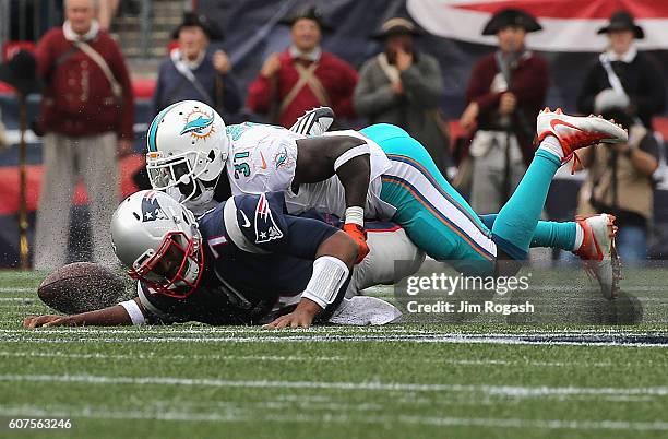 Jacoby Brissett of the New England Patriots fumbles the ball as he is sacked by Michael Thomas of the Miami Dolphins during the second half at...