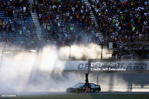 Martin Truex Jr, driver of the Furniture Row/Denver Mattress Toyota, celebrates after winning the NASCAR Sprint Cup Series Teenage Mutant Ninja...