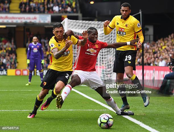 Paul Pogba of Manchester United battles with Jose Holebas and Etienne Capoue of Watford during the Premier League match between Watford and...