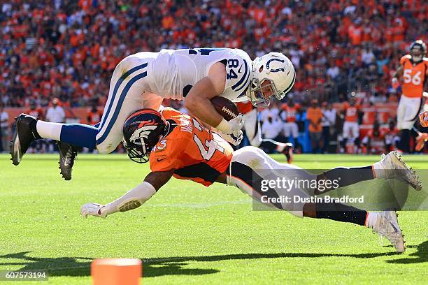 Strong safety T.J. Ward of the Denver Broncos tackles tight end Jack Doyle of the Indianapolis Colts in the red zone in the third quarter of the game...