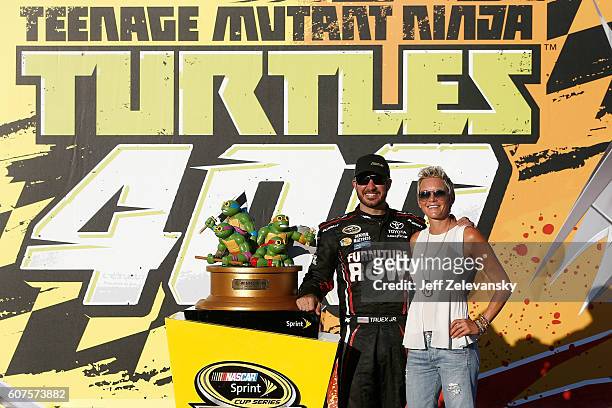 Martin Truex Jr, driver of the Furniture Row/Denver Mattress Toyota, poses with the trophy in Victory Lane with his wife Sherry Pollex after winning...
