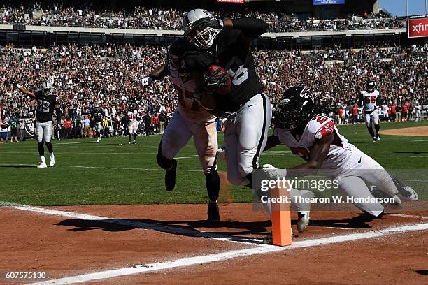 Clive Walford of the Oakland Raiders scores on a 31-yard touchdown catch against the Atlanta Falcons during their NFL game at Oakland-Alameda County...