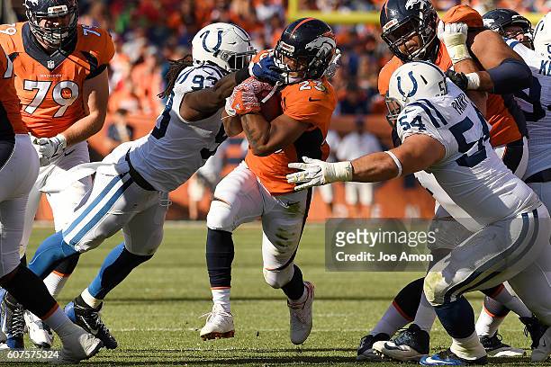 Devontae Booker of the Denver Broncos takes a hand to the face from Erik Walden of the Indianapolis Colts as David Parry closes in for a tackle...