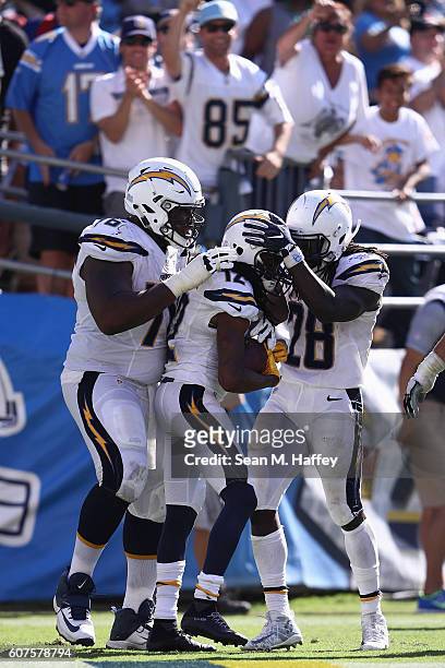 Chargers fans cheer as D.J. Fluker and Melvin Gordon of the San Diego Chargers celebrate with Travis Benjamin after Benjamin scored against the...