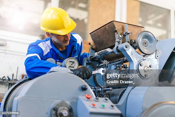 arbeiter in der fabrik repariert hydraulische pressen und rollbügel - produktionsgerät stock-fotos und bilder