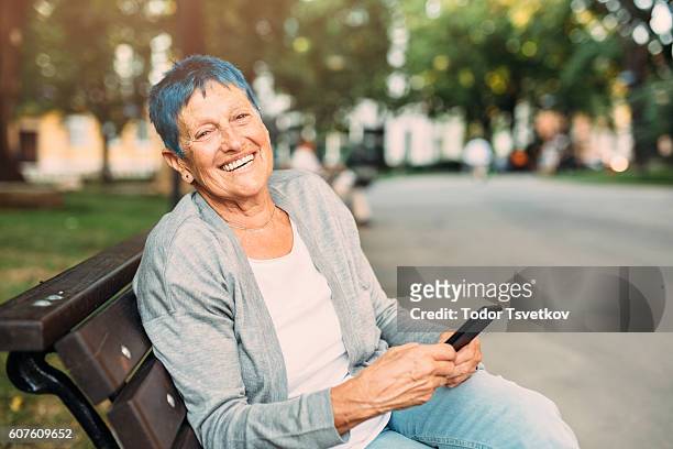 happy senior woman texting - older woman colored hair stock pictures, royalty-free photos & images