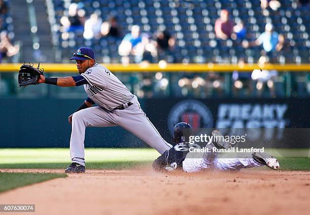 Raimel Tapia of the Colorado Rockies steals second base as Luis Sardinas of the San Diego Padres receives the throw during the bottom of the seventh...