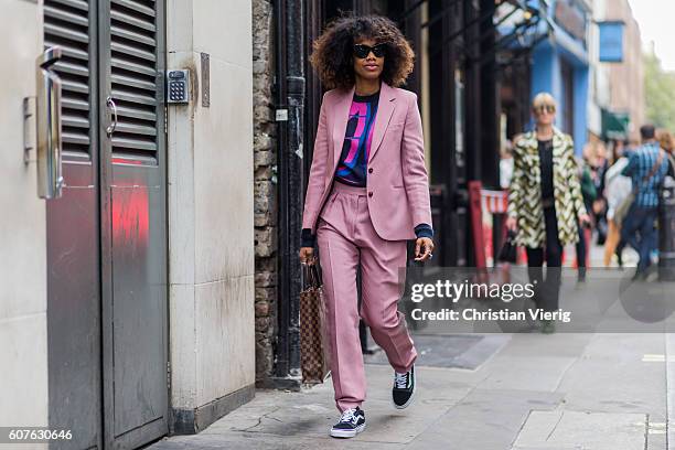 Fashion Director Instyle Germany Jan-Michael Quammie wearing a pink suit, Louis Vuitton bag and Vans outside Mary Katrantzou during London Fashion...