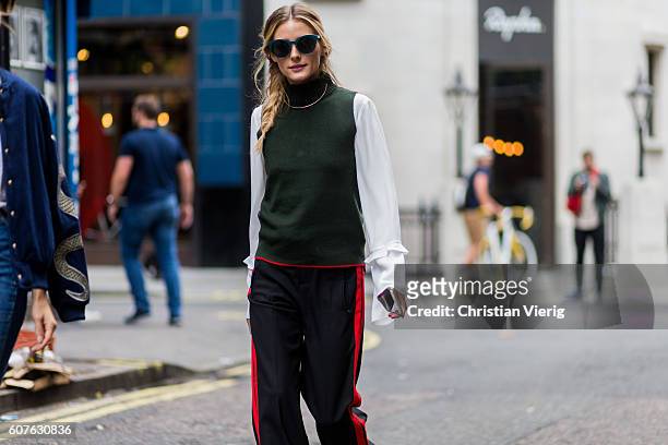 Olivia Palermo wearing sunglasses, a green sleeveless jumper, white blouse, black track suit pants outside Mary Katrantzou during London Fashion Week...