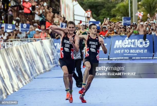 British athlete Alistair Brownlee helps his brother Jonathan Brownlee before crossing the line in second and third place during the ITU World...