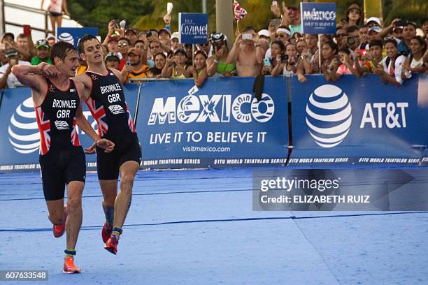 British athlete Alistair Brownlee helps his brother Jonathan Brownlee before crossing the line in second and third place during the ITU World...