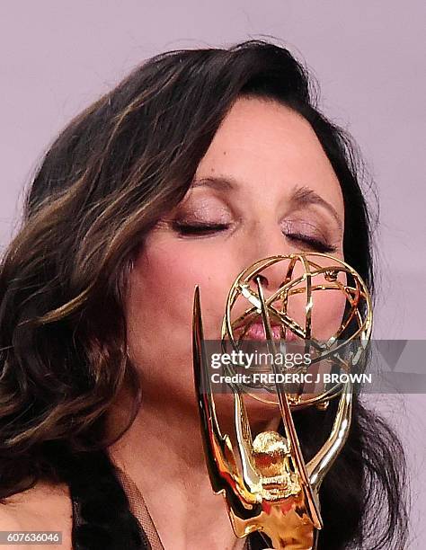 Julia Louis-Dreyfus poses in the press room with the Emmy for Outstanding Lead Actress in a Comedy Series for "Veep" during the 68th Emmy Awards on...