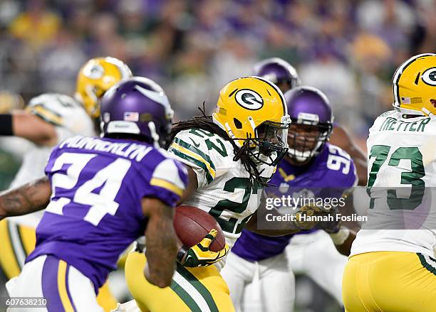 Eddie Lacy of the Green Bay Packers carries the ball while being pursued by defender Captain Munnerlyn of the Minnesota Vikings in the first half of...