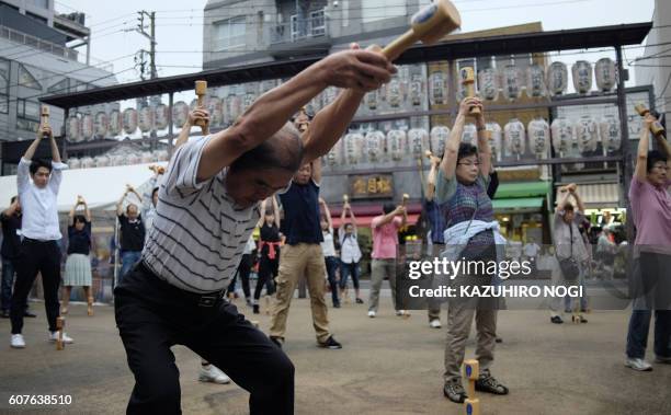 Elderly people work out with wooden dumb-bells in the grounds of a temple in Tokyo on September 19 to celebrate Japan's Respect for the Aged Day.