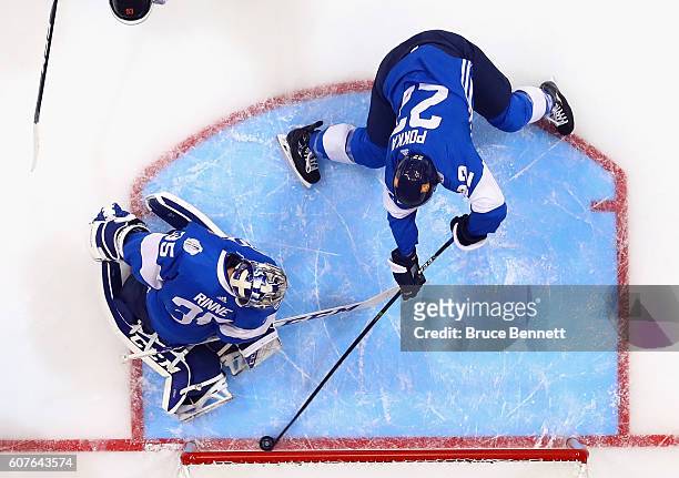 Ville Pokka of Team Finland pushes the puck away from the goalline in front of Pekka Rinne during the game against Team North America during the...
