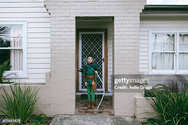 child in front of house in robin hood costume - jodie griggs stock pictures, royalty-free photos & images