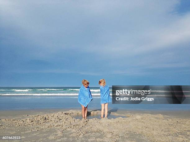 children playing together in water & sand at beach - telo da mare foto e immagini stock