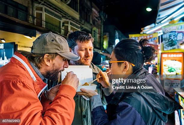 friends eating with chopsticks asian night market - night market stock pictures, royalty-free photos & images