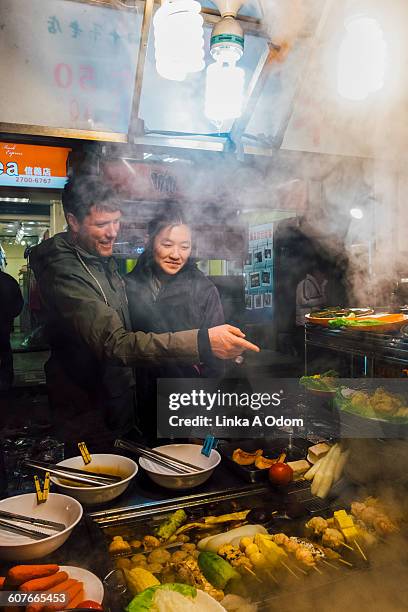 mixed race couple shopping in outdoor asian market - taipei market stock pictures, royalty-free photos & images