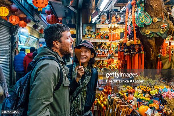 mixed race couple shopping in outdoor asian market - taipé imagens e fotografias de stock