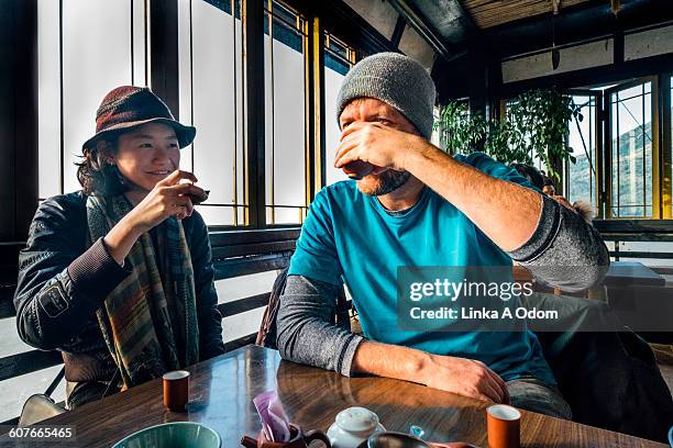 mixed race couple drinking tea - mixed race woman drinking tea stock-fotos und bilder