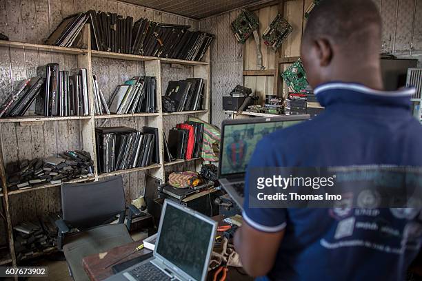 Accra, Ghana Workshop on the biggest electronic scrap yard in Agbogbloshie, a district in Ghana's capital. A young African dismantles old laptops on...